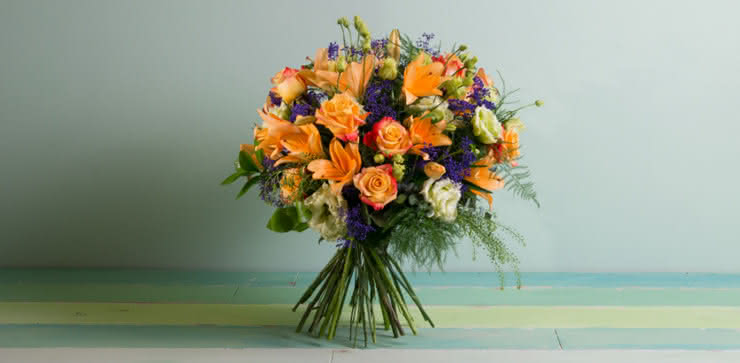 Enviar arranjo de rosas e liliums em tons de laranja ao domicílio